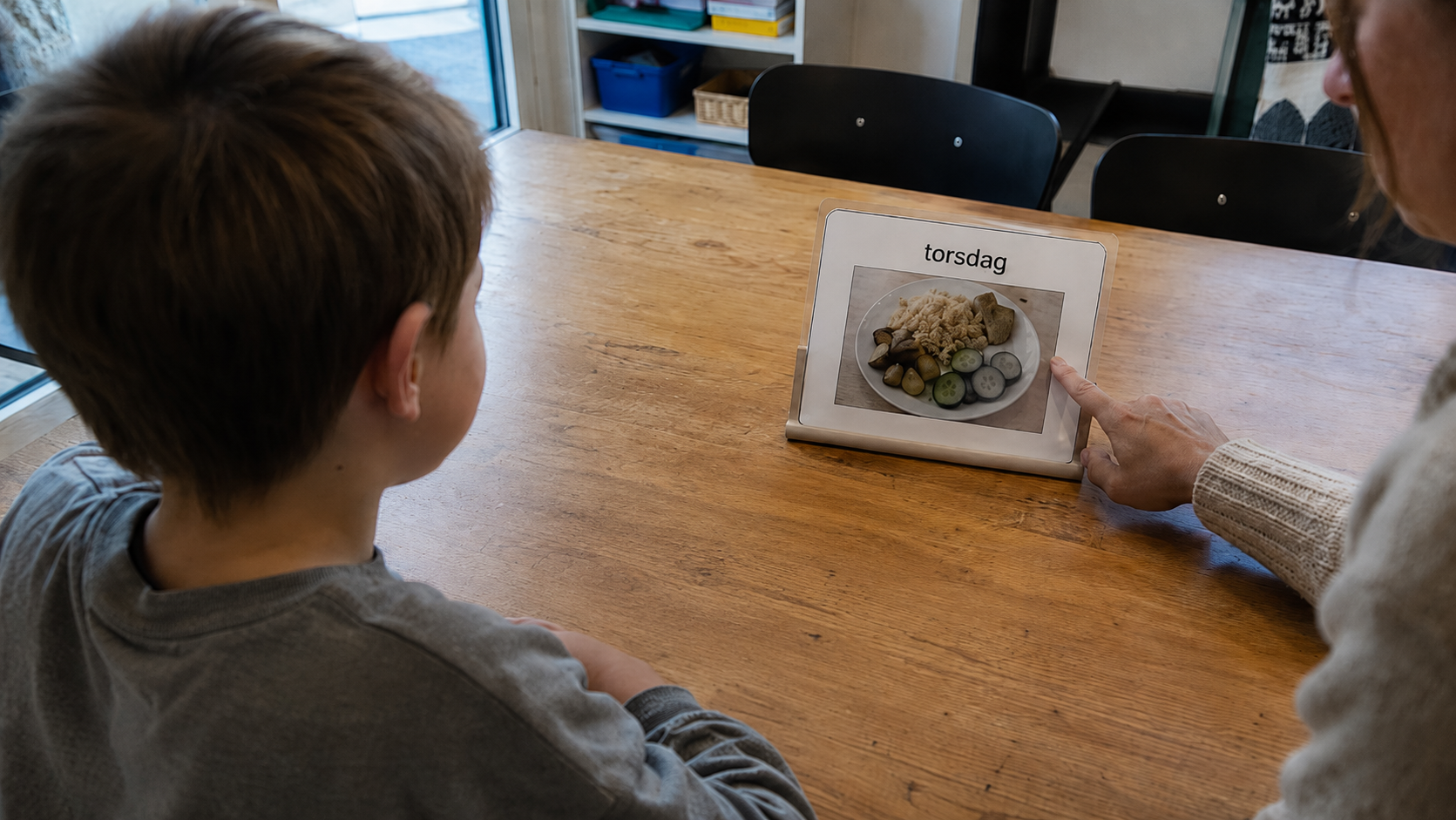 Barn som kigger på et piktogram af det måltid som han skal have om torsdagen